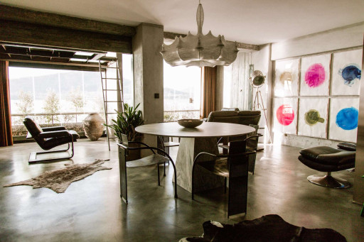 Open-plan dining and living space with designer lighting and floor-to-ceiling windows overlooking the Minho River
