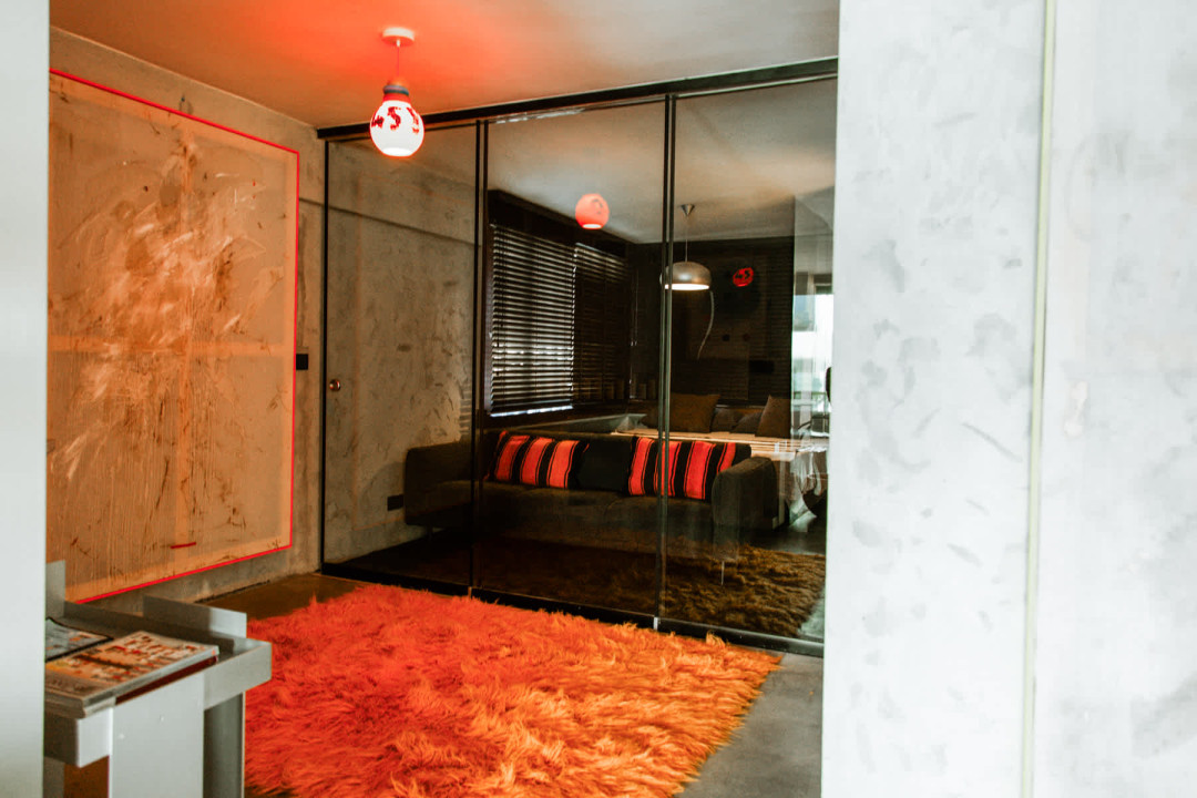 Cosy lounge area with burnt-orange rug and contemporary lighting creating an intimate evening retreat.