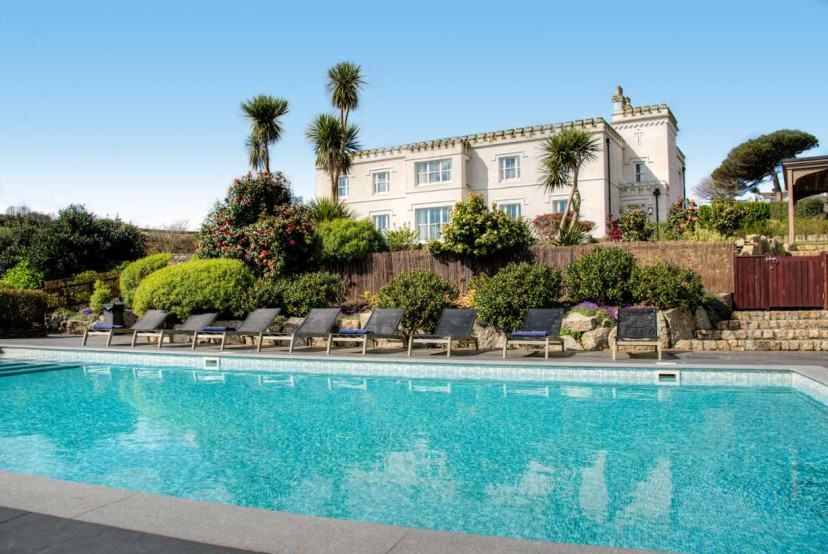 Elegant outdoor pool with sweeping coastal views across the estate grounds