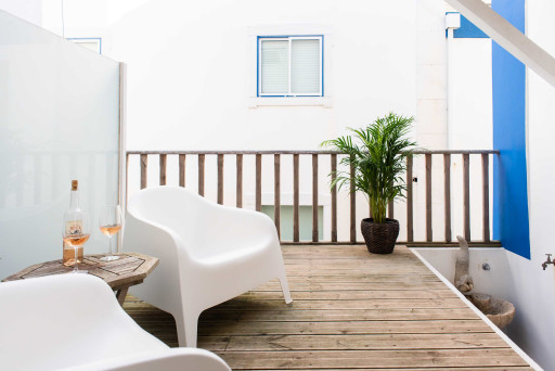 Santo Antonio 1 relaxing balcony with comfortable seating and a touch of greenery.