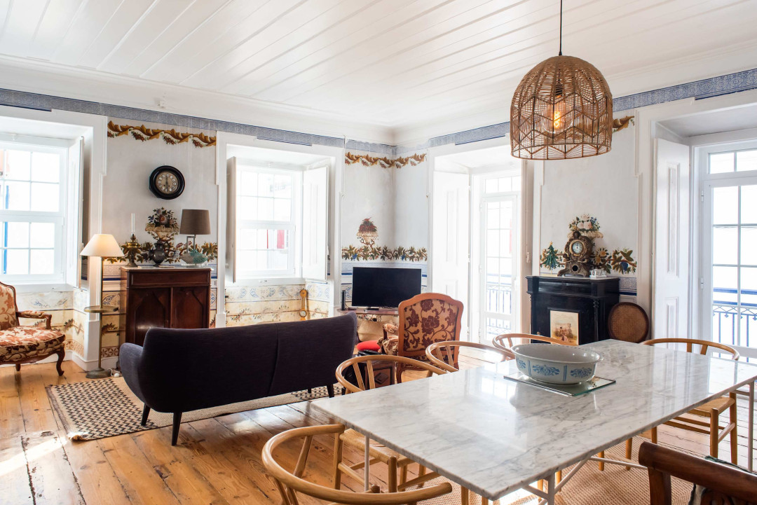 Santo Antonio 1 spacious living area with large windows, showcasing a blend of antique and modern furniture.