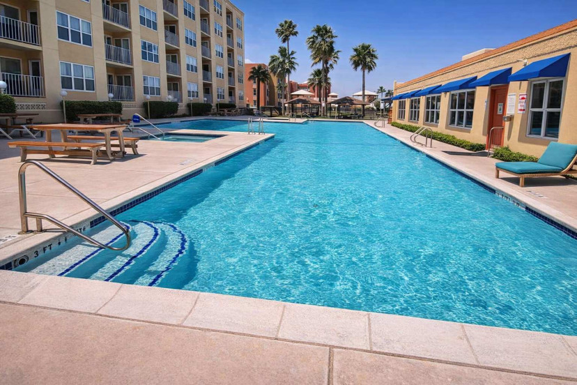 Resort-style pool retreat with tub, picnic tables, lounge chairs & palm-lined relaxation near the beach—perfect for families, couples, and group getaways.