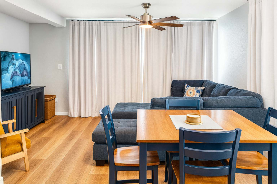 Relax in this inviting living space featuring a comfy sectional, stylish dining area, and modern decor. A perfect spot to unwind with family and friends, equipped for movie nights and casual meals in a bright, open atmosphere.