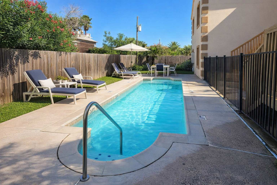 Relax by the sparkling Pool – Cozy Outdoor Retreat with Lounge Seating, Dining Area & Fenced Privacy Near Beach