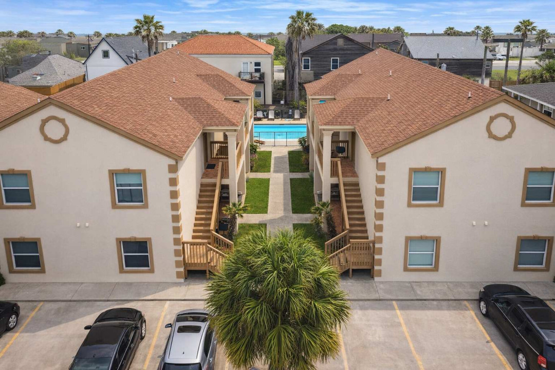 Stylish twin apartments with gated pool, palm-lined walkway, and private stair access—perfect for families or groups seeking comfort, convenience, and shared amenities near the beach.