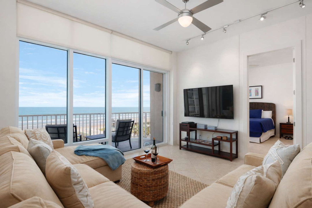 Modern beachfront condo with panoramic ocean views, cozy sectional seating, private balcony, and open-concept layout. Steps from the sand, perfect for couples or small families seeking a relaxing coastal escape.