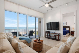Modern beachfront condo with panoramic ocean views, cozy sectional seating, private balcony, and open-concept layout. Steps from the sand, perfect for couples or small families seeking a relaxing coastal escape.