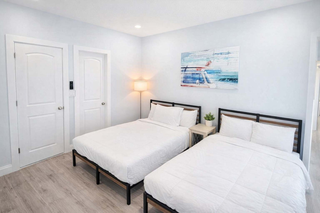 Modern Twin Room Near Beach – Cozy Beds, Soft Lighting, Clean Design, and Vibrant Coastal Art. Ideal for Friends, Couples, or Solo Travelers Seeking Comfort and Style.