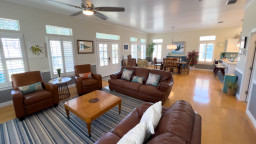 Bright, open living with coastal charm—this spacious great room features comfy leather seating, abundant natural light, a large dining area & a modern kitchen. Ideal for gathering, relaxing or entertaining in a refreshing, beach-inspired atmosphere.
