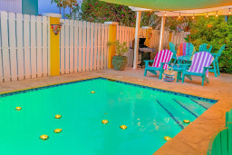 Chill by the inviting pool at this vibrant, coastal retreat, complete with Adirondack chairs, a shaded pergola, BBQ grill, and string lights. Enjoy a colorful, fun-filled outdoor oasis, ideal for relaxing and entertaining after a day at the beach.