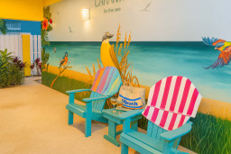 Enjoy the vibrant outdoor shower lounge at Canary by the Sea, featuring playful murals, aqua Adirondack chairs, and beachy décor. This fun, shaded spot is ideal for rinsing off or unwinding after a day in the sun and surf.