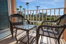 Sunny Balcony Retreat with Palm Views – Relaxing Wicker Seating & Glass Table, Steps from Coastal Vibes
