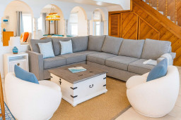Relax in the inviting living room with a plush sectional, chic swivel chairs and stylish accents. Spacious, light-filled layout is perfect for game nights or unwinding. Enjoy comfort and coastal charm just steps from entertainment & gathering spaces.
