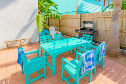 Host the perfect outdoor gathering with a turquoise dining set, grill, and tropical vibe. Shaded by palms, this patio is ideal for alfresco meals, barbecue nights, and drinks with friends. Relax and dine in a fun, cheerful space under sunny skies.