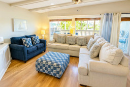 Cozy Coastal Living Room Bliss
Inviting open living space in South Padre retreat! Navy velvet sofas, plush beige sectional, patterned ottoman. Large windows w/ beach art, chandelier glow, balcony access. Perfect for family lounging near Gulf.