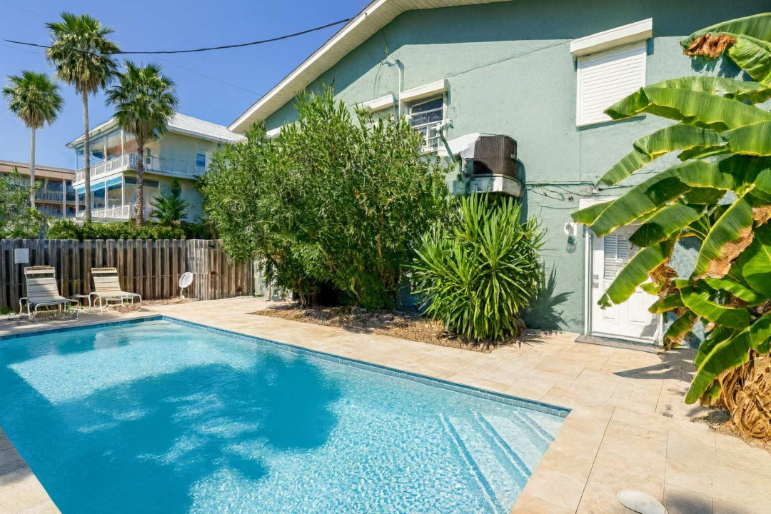 A bright poolside corner wrapped in lush greenery and soft light, creating an easygoing place to unwind, settle into the warm outdoor atmosphere, and enjoy the simple, relaxed rhythm of a sunny retreat that feels naturally welcoming.