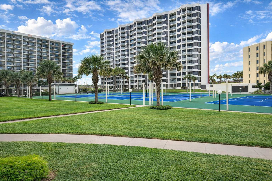 Resort-style condo with tennis courts, palm-lined walkways, and high-rise views—steps from the beach and perfect for active getaways or relaxing retreats.