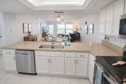Modern open-concept kitchen & living area with granite counters, stainless steel appliances, natural light, and cozy seating—perfect for relaxing or entertaining in style.