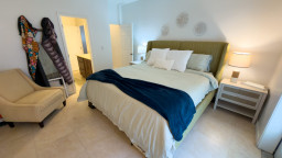 A calm, inviting bedroom designed for slow mornings and easy evenings, with soft light, warm textures, and a relaxed flow into the ensuite—an easy space to settle in, unwind, and feel at home throughout your stay.