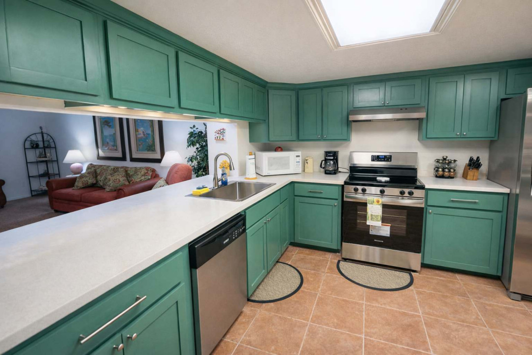 Modern Green Kitchen + Cozy Living Room View | Stainless Steel Appliances | Bright, Clean & Fully Equipped | Ideal for Families or Long Stays