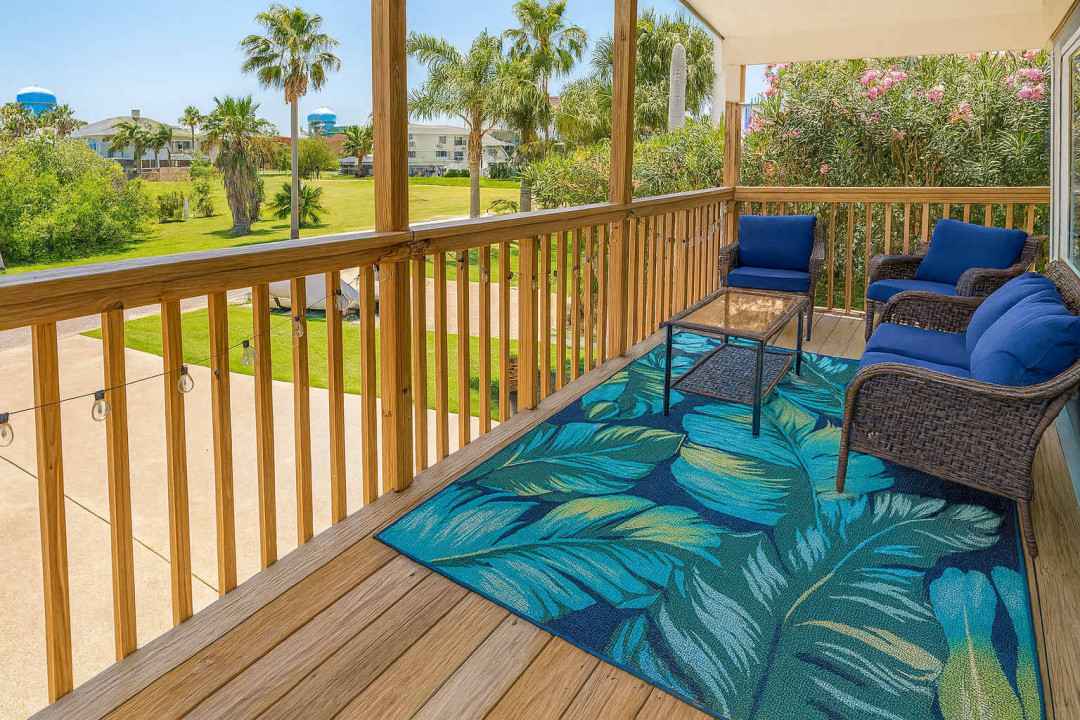 Tropical Balcony Retreat with Plush Seating & Lush Views
Unwind on a bright balcony with deep-cushioned wicker seating, vibrant tropical rug, and serene palm-lined views — perfect for morning coffee or sunset wine.