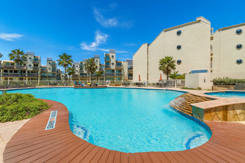Tropical Poolside Escape with Waterfall & Modern Condos
Relax in a sunlit resort-style pool with cascading waterfall, palm trees, and sleek architecture. Lounge deck, umbrellas, and spa vibes—perfect for your South Padre Island getaway.