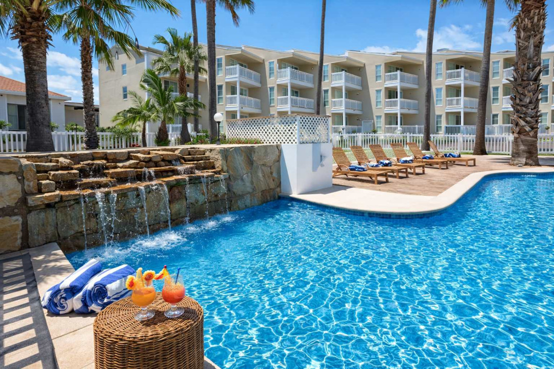 A bright, refreshing poolside space that feels effortlessly calm, where sunlight and clear water create a natural sense of ease. The open layout and tropical touches make it a simple, inviting spot to unwind and enjoy slow coastal moments.