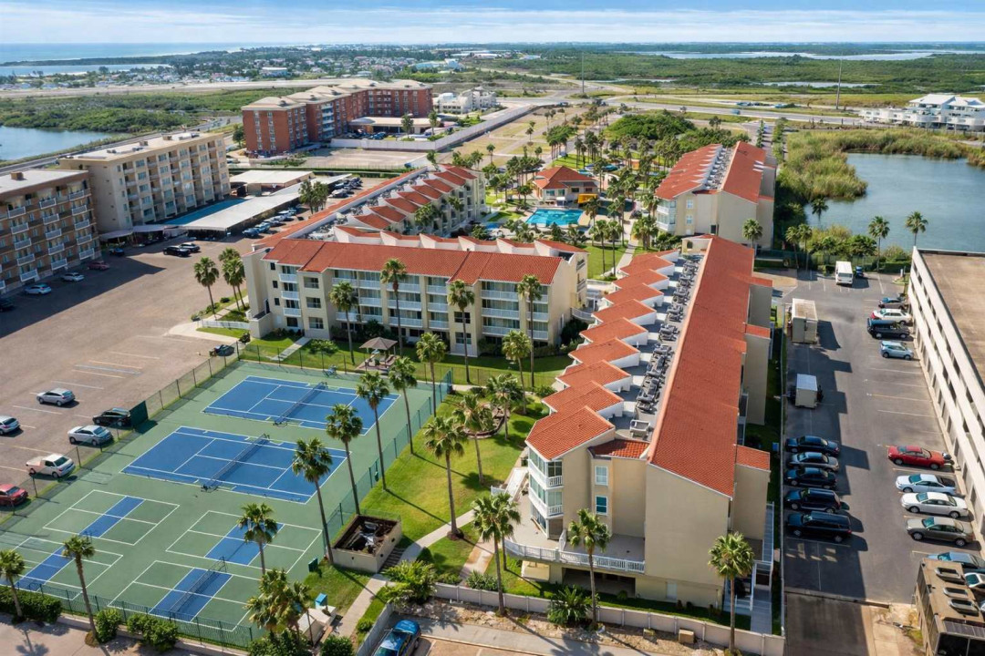 Sunlit coastal retreat with red-tiled roofs and tropical palms, offering a serene escape near the shoreline. Enjoy breezy mornings, vibrant sunsets, and a relaxed resort vibe that feels both private and connected to the coast’s rhythm.