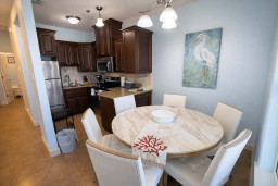 Bright, coastal kitchen & dining with granite counters, stainless appliances, and heron artwork—perfect for relaxed meals and morning coffee.