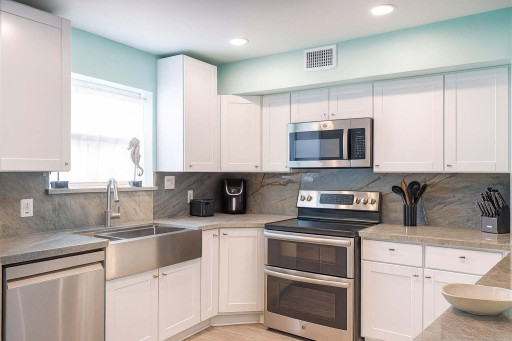 Modern Kitchen with Stainless Steel Appliances, Marble Counters, Farmhouse Sink & Natural Light—Perfect for Cooking & Entertaining