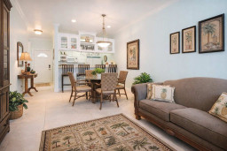 Bright, Coastal Kitchen & Entryway | Stylish Bar Seating, Tropical Accents, Glass Cabinets, and Inviting Decor Steps from the Beach