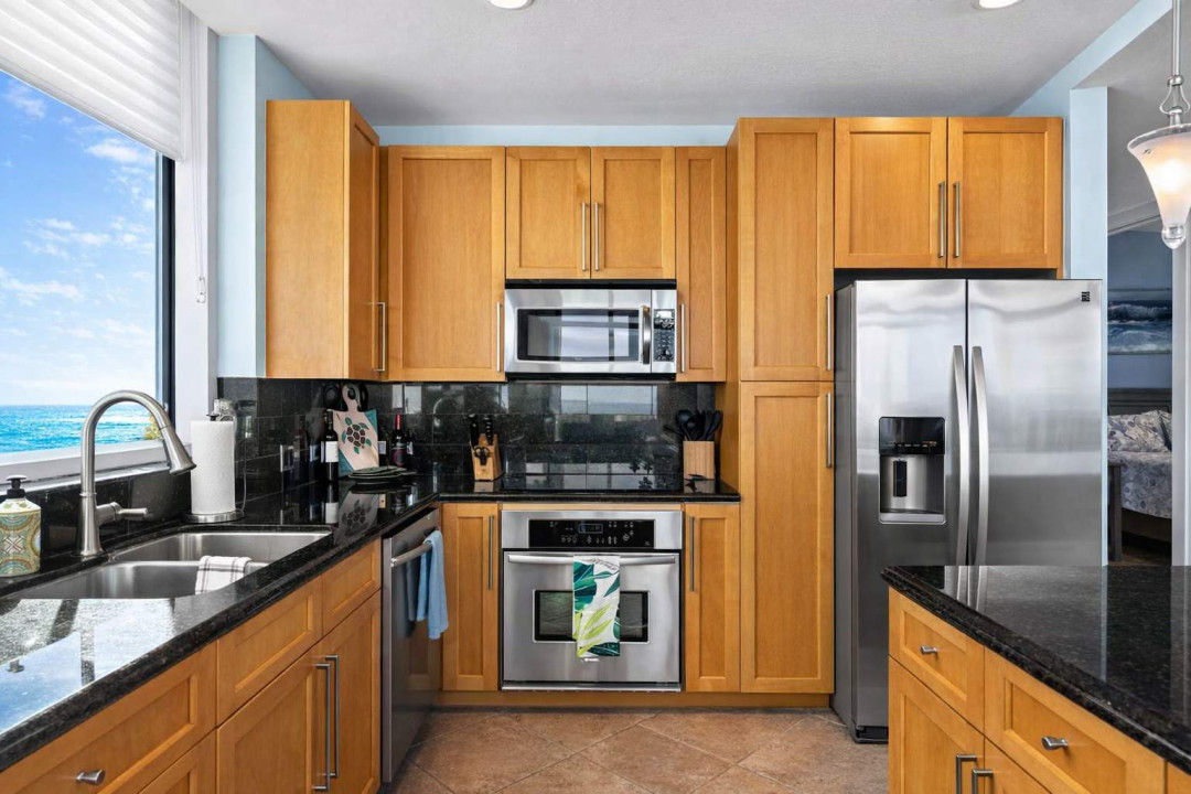 Modern Kitchen with Ocean View – Stainless Steel Appliances, Granite Counters, Double Sink, and Sleek Cabinetry. Bright, Clean, and Fully Equipped for Your Stay.