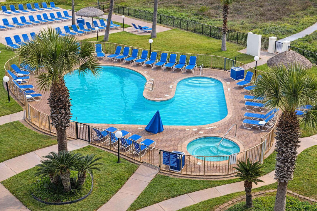 Resort-style pool retreat with outdoor tub, palm trees, and lounge seating—perfect for relaxing coastal getaways. Steps from beach access, ideal for families or couples seeking sun-soaked leisure.