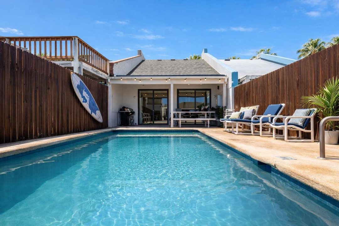 Sunlit retreat with a private pool framed by coastal wood accents and breezy patio charm. Perfect for slow mornings or sunset dips, this space blends warmth and ease—inviting guests to unwind, connect, and savor island living at its best.