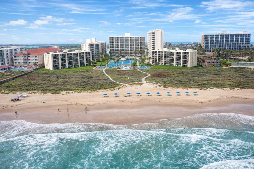Beachfront resort with ocean views, poolside paradise, and direct beach access—perfect for family getaways or romantic escapes. Walk to the waves, relax under blue umbrellas, and enjoy spacious condos with private balconies and lush landscaping.