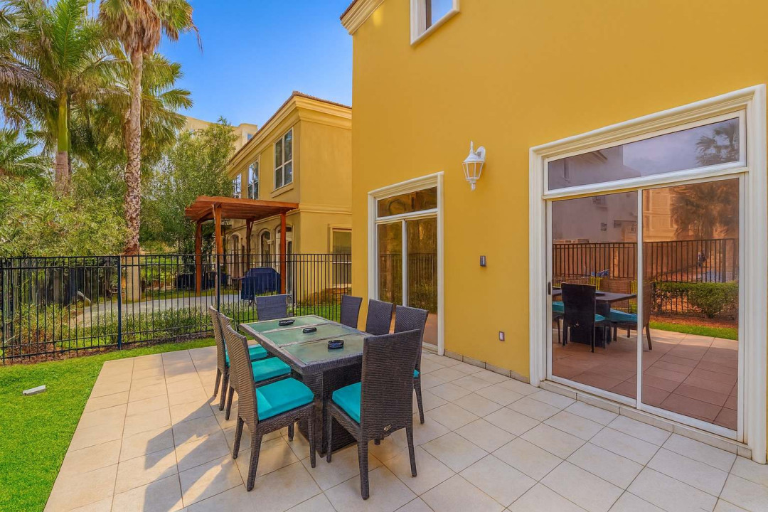 Tropical Patio Retreat with Dining Area, BBQ Pergola & Palm-Lined Privacy Fence