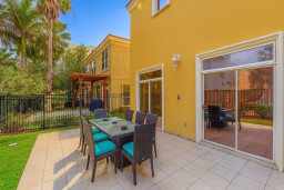 Tropical Patio Retreat with Dining Area, BBQ Pergola & Palm-Lined Privacy Fence