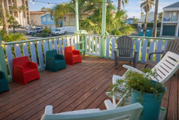 Colorful Coastal Deck w/ Kid & Adult Seating + Palm Views – Walk to Beach, Shops & Eats