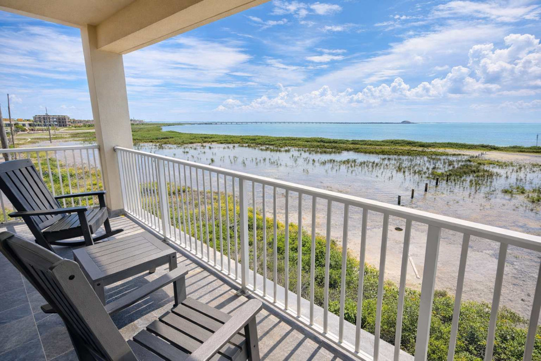 Waterfront balcony with panoramic marsh views, comfy Adirondack seating, and serene sunsets near the bridge—perfect for morning coffee or evening wine.