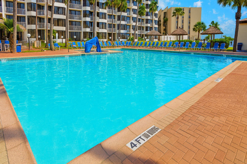 Royale Beach Resort Sparkling Pool
Expansive turquoise pool at Royale Beach & Tennis Club, backed by 9-story towers & palms. Lounge chairs, tiki umbrellas, bubbling spa—sun-drenched oasis steps from South Padre sands. Tennis & beach paradise awaits.