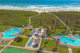 Royale Beach Dual Oceanfront Pools
Twin freeform pools with spas at Royale Beach & Tennis Club, mere steps from South Padre's sandy shore. Tiki umbrellas, loungers, tennis courts amid palms. Beachfront bliss for sun, swim, sport lovers.