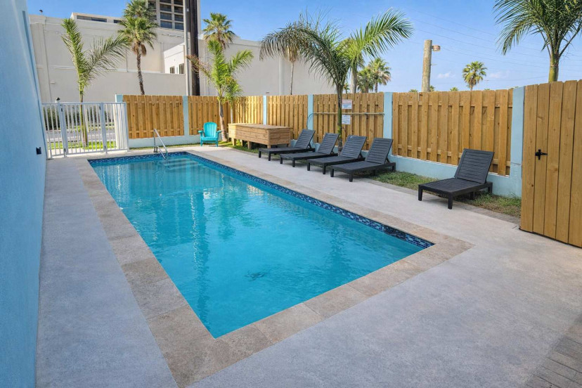 Private Pool Retreat | Tropical Vibes | Lounge Chairs & Hot Tub | Walk to Beach | Palm-Lined Privacy Fence | Ideal for Families & Groups | Clean, Bright, Relaxing Outdoor Space | Coastal Comfort Near Attractions