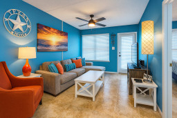 Unwind in this cozy, beach-inspired living room featuring a comfy sectional, HDTV, fast WiFi, and vibrant coastal decor. Enjoy movie nights or relax after a day at the shore in a bright, welcoming space with plenty of natural light.