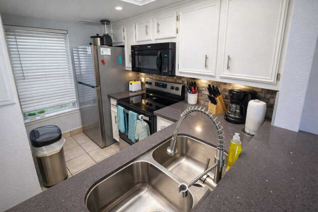 Modern Kitchen with Stainless Steel Appliances, Coffee Station, and Bright Natural Light – Perfect for Short-Term Stays