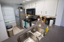 Modern Kitchen with Stainless Steel Appliances, Coffee Station, and Bright Natural Light – Perfect for Short-Term Stays