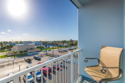 Sunny balcony with coastal views, steps from the marina. Enjoy morning coffee overlooking palm-lined streets and boats in the distance. Bright, breezy, and walkable to dining, beach, and attractions—perfect for your South Padre escape.