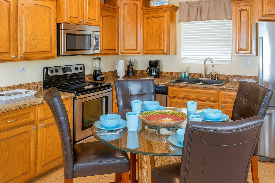Sunny Kitchen Dining Haven
Warm oak cabinets, stainless steel appliances, glass dining table—ideal for beachy meals! Spacious SPI kitchen near harbor & sands. Cook, dine, & savor Gulf vibes at 113 E Pompano St.