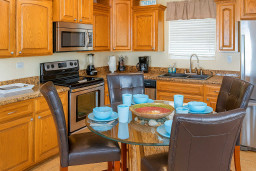Sunny Kitchen Dining Haven
Warm oak cabinets, stainless steel appliances, glass dining table—ideal for beachy meals! Spacious SPI kitchen near harbor & sands. Cook, dine, & savor Gulf vibes at 113 E Pompano St.