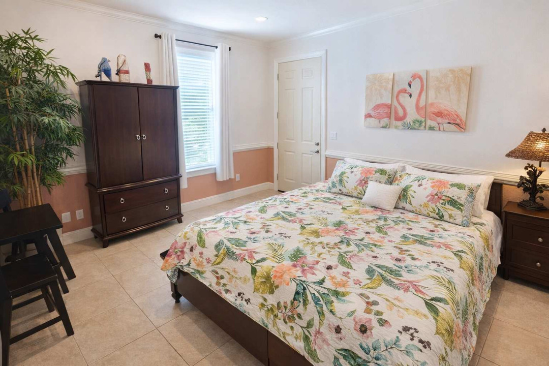 Tropical Retreat Near Beach | Flamingo Art | Bright & Airy | Comfortable Bed | Coral Accents | Natural Light | Armoire + Seating | Ideal for Couples & Solo Travelers | Fast WiFi | Walk to Dining & Shops