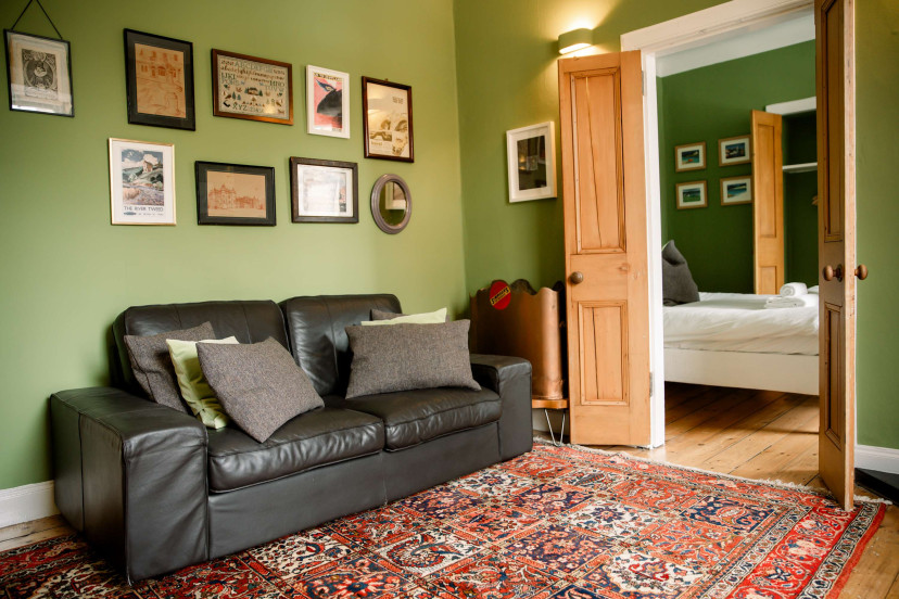Cozy living room w/ leather sofa, gallery wall & warm lighting for laid-back evenings